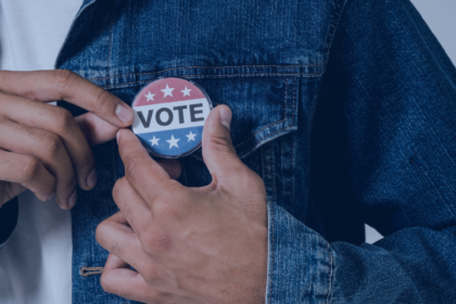 Photo of a voter wearing a Vote pin.